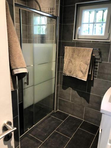 une douche avec une porte vitrée dans une salle de bain dans l'établissement Résidence 04094-lacanau - Maison familiale dans un complexe au calme près du lac MAE-0971, à Lacanau