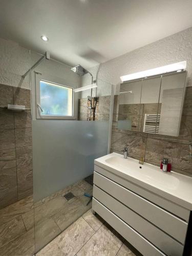 une salle de bain avec un lavabo, un miroir et une baignoire dans l'établissement Résidence 05029-lacanau Ocean - Villa pour 9 personnes avec jardin et jacuzzi à Lacanau Océan MAE-1001, à Lacanau