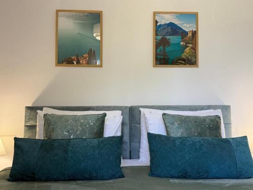 a bed with two pillows and two pictures on the wall at La Vista Residence - 5 BDS, 2 private swimming pools, stunning sea views only 10 minutes from Corfu Town's Centre in Gouvia
