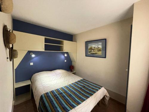 une chambre avec un lit avec un mur bleu dans l'établissement Résidence Lacanau Les Pins - 01424_ Appartement T2 avec piscine collective chauffée MAE-1041, à Lacanau