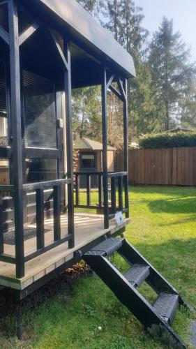 a wooden gazebo in a yard at Pipowagen Bed bij Bos in Putten