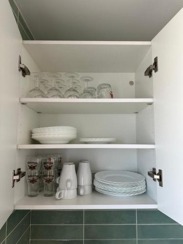 ein Schrank mit Tellern und Geschirr in einer Küche in der Unterkunft O Refuxio da Ría in Pontevedra