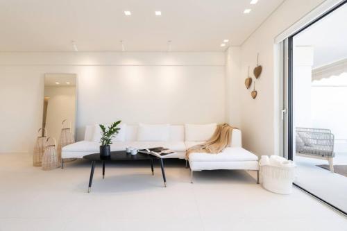 Una sala de estar con un sofá blanco y una mesa. en 2bd Boho Sea View Apartment By The Olon, en Vari