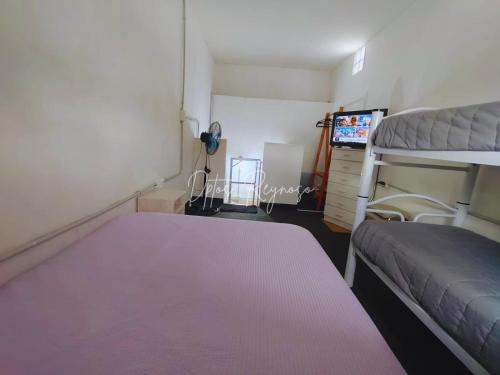 a bedroom with two bunk beds and a tv at Dptos Reynoso in Villa Mercedes