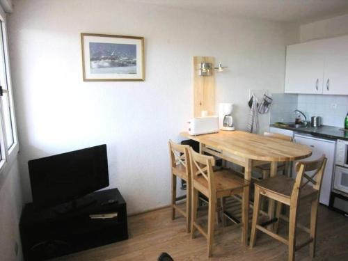 - une cuisine avec une table et des chaises en bois dans la chambre dans l'établissement Résidence Ortal - Appartement 4 personnes vue océan, orienté sud, 30m de la plage, Lacanau Océan MAE-1121, à Lacanau