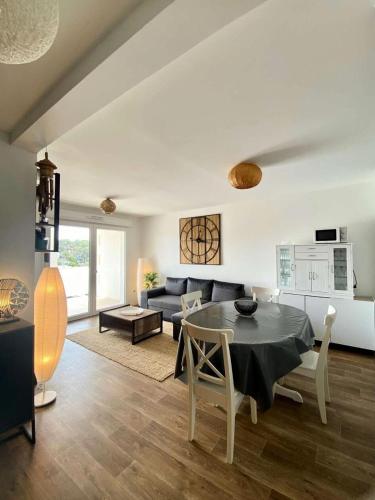 un salon avec une table et un canapé dans l'établissement Résidence Les Embruns - Appartement neuf à proximité des commodités pour 4 personnes avec parking MAE-9381, à Lacanau