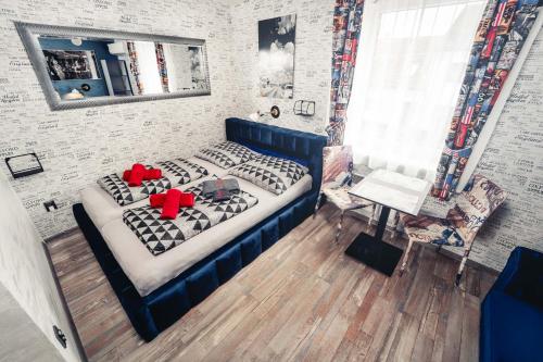 a bedroom with a blue bed with red pillows at Penzion Hádlík in Velké Pavlovice