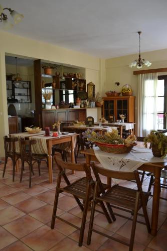 a dining room with tables and chairs and a kitchen at Ξενώνας Αλώνι-Guesthouse Aloni in Theodoriana