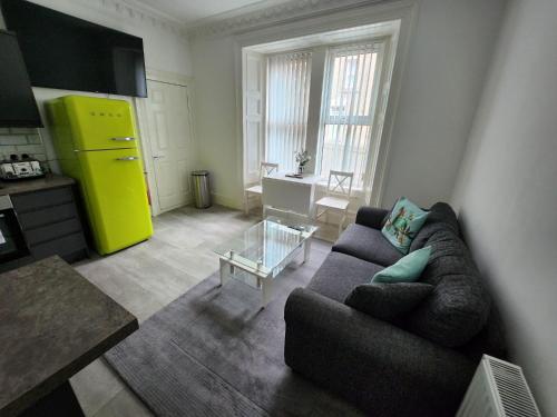 a living room with a couch and a yellow refrigerator at Spacious Apt Dundee dockside 3-bedrooms fast Wi-Fi in Dundee
