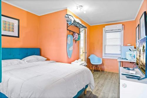 a bedroom with a bed and an orange wall at Step Back in Time- Golden Era Retro Motel in Saint Augustine