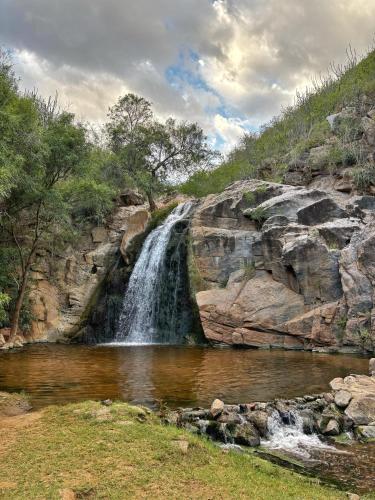 a waterfall in front of a large rock formation at Viver de Temporada Canindé- 15 Minutos de Piranhas in Canindé de São Francisco