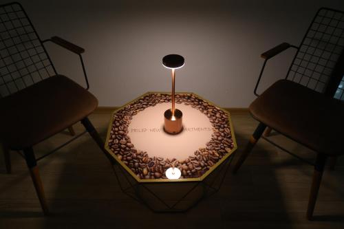 a table with a candle in a room with two chairs at PRILEP NEW BEST APARTMENTS in Prilep