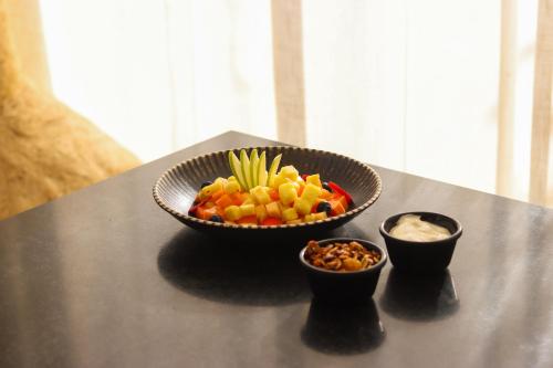 a bowl of fruit on a table with two bowls of nuts at Trobbu Boutique Collection Tulum - All inclusive in Tulum