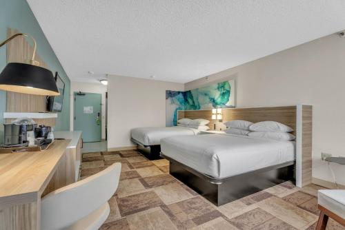 a hotel room with two beds and a kitchen at Wyndham Garden Newark Fremont Silicon Valley in Newark