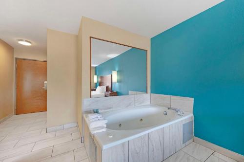 a bathroom with a tub and a large mirror at Best Western Central City in Central City