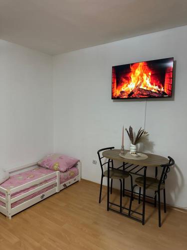 Habitación con mesa, cama y chimenea. en Apartment Dedić, en Sarajevo