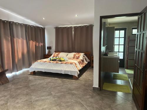 a bedroom with a bed and a large window at Villa Te Torea in Arue