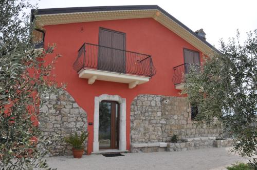 a red house with two windows and a balcony at Agriturismo San Michele in Paternopoli