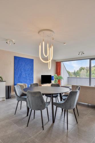 a dining room with a table and chairs and a chandelier at Ruim 2 slaapkamer appartement met parking nabij NAVO in Machelen