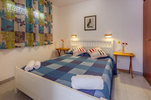 1 dormitorio con 1 cama con manta a cuadros en Hola Sitges Apartments, en Sitges