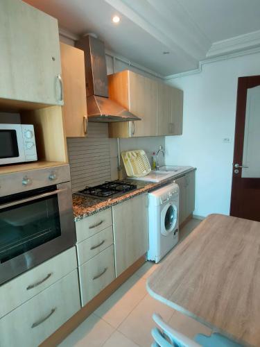 a kitchen with a stove top oven next to a table at luxurious and cosy apartment close to tunsia mall lac 2 in El Aouina Station