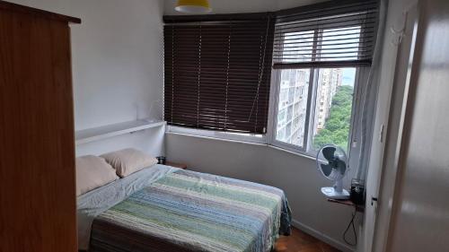 a small bedroom with a bed and a window at Apê em Copacabana in Rio de Janeiro