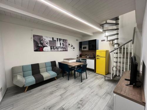 a living room with a couch and a table and a kitchen at Baratà Apartments 1 in Savigliano