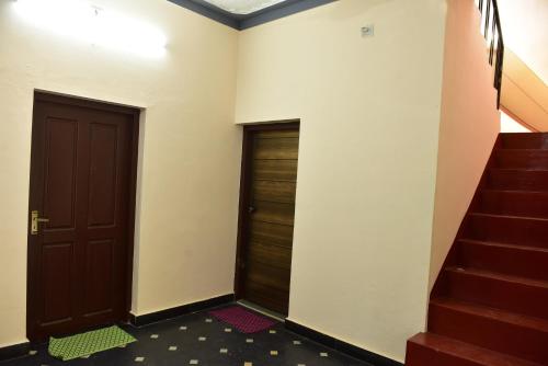 a hallway with two doors and a staircase at Abrahams Beach House in Edakkād