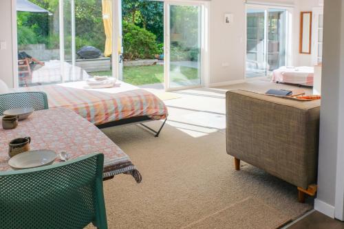 a living room with a table and chairs at Studio Wing in Saint Heliers in Auckland