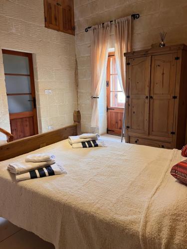 a bedroom with a large bed with two towels on it at Arkati house in Munxar