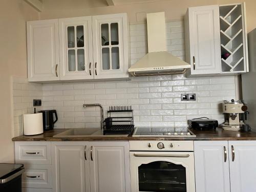 a kitchen with white cabinets and a stove top oven at Blue Horizon Rock in Nydri
