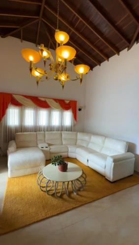 a living room with a white couch and a table at VILLA ORION piscina y discoteca PRIVADA K18 in Cali