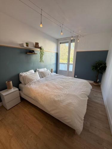 a bedroom with a large white bed in it at Le Cocon in Beauvais