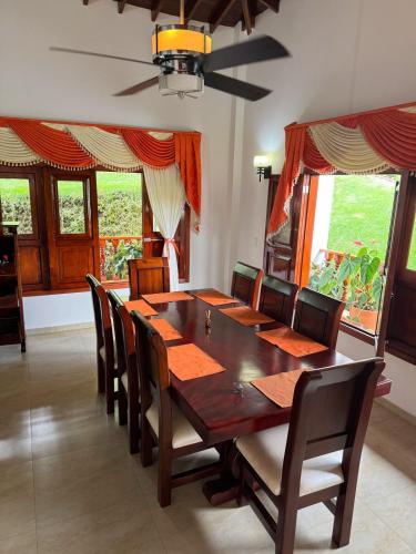 a dining room with a wooden table and chairs at VILLA ORION piscina y discoteca PRIVADA K18 in Cali
