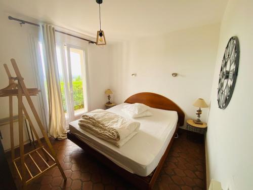 - une chambre dotée d'un lit avec une horloge murale dans l'établissement Maison au calme dans résidence privée avec piscine vue mer, à Fréjus