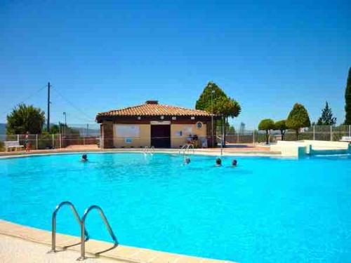 une grande piscine bleue avec un bâtiment en arrière-plan dans l'établissement Maison au calme dans résidence privée avec piscine vue mer, à Fréjus