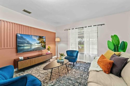 a living room with a couch and a tv at SUPER BOHO - Lake Toho Timeless Charm in Kissimmee