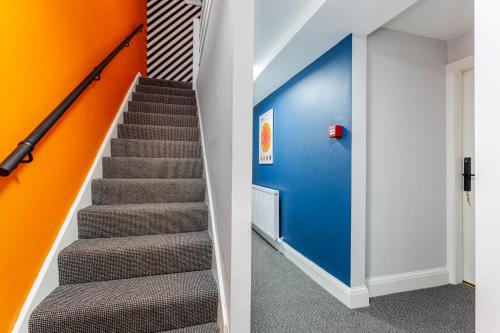 a staircase with blue and orange walls and a stair case at Ashton Getaway Sleeps 14 Free Parking in Dukinfield