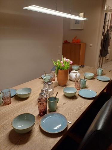 a wooden table with blue plates and flowers on it at Tillyhome in Nürnberg