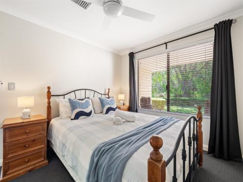 a bedroom with a bed and a large window at Busselton Broadwater Holiday Home in Busselton