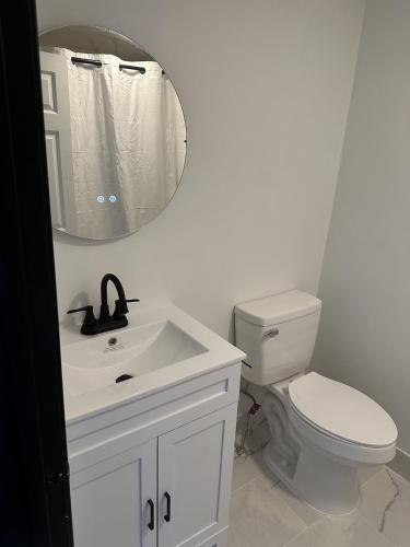 a bathroom with a white toilet and a mirror at Harborside Suites in Yarmouth