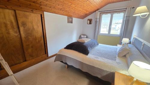 a bedroom with a bed and a window at MV Vacances in Les Rousses