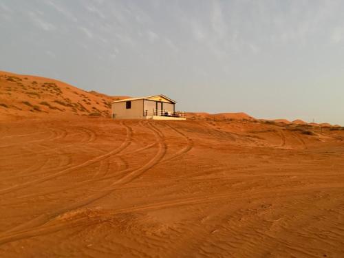 a house on top of a dirt road in the desert at Marbella bungalows desert private camp in Bidiyah