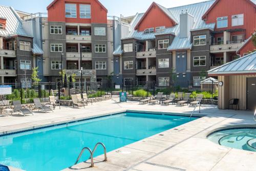 a swimming pool in front of some apartment buildings at Lake Placid Lodge by Whiski Jack in Whistler
