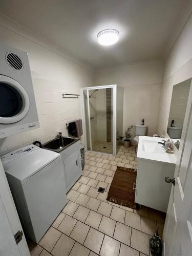 a bathroom with a sink and a washing machine at Downtown Narrabri Apartment in Narrabri