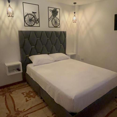 a bedroom with a bed with a bicycle on the wall at Hostal Ángel Victoria in Yopal