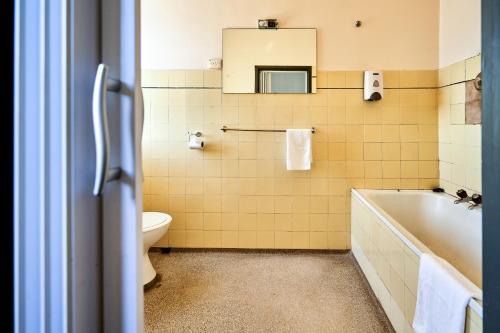 a bathroom with a tub and a toilet and a sink at Beer Deluxe Albury in Albury