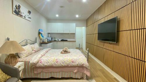 a bedroom with a bed and a television on a wall at Modern Studio Room Retreat in Harristown