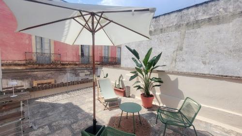 a patio with a table and chairs and an umbrella at Casa Brumar in Nardò