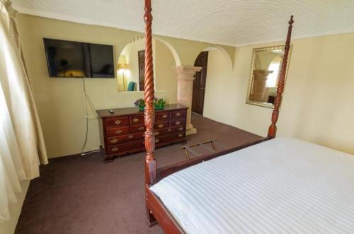 a bedroom with a bed and a dresser and a mirror at Hotel Castillo de Santa Cecilia in Guanajuato